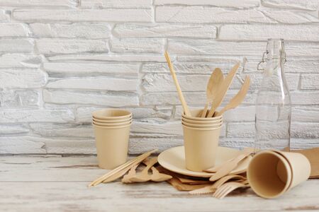 Eco friendly disposable dishes made of bamboo wood and paper on white wooden background. Zero waste, eco friendly, plastic free background.の写真素材