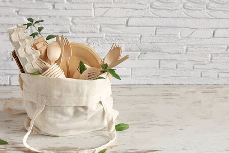 Eco friendly disposable dishes made of bamboo wood and paper on white wooden background. Zero waste, eco friendly, plastic free background.の写真素材