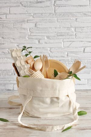 Eco friendly disposable dishes made of bamboo wood and paper on white wooden background. Zero waste, eco friendly, plastic free background.の写真素材