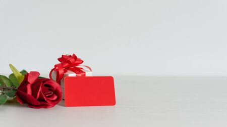 Valentines or anniversary gift and a bunch of beautiful red roses with an attached red blank gift tag for your greetings or message. Copy space.の写真素材