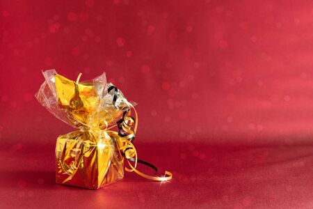 Golden gift box on colored background with bokeh. Holiday present concept. Copy space for your text.の写真素材