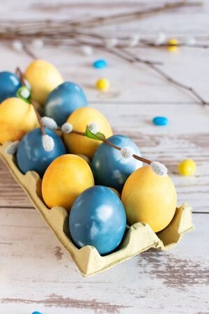Marble blue and yellow colored easter eggs on wooden table. Easter holiday card.の写真素材