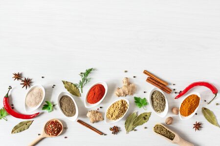 Various assorted colorful spices and herbs on white wooden background top view. Flat lay. Copy space.の写真素材