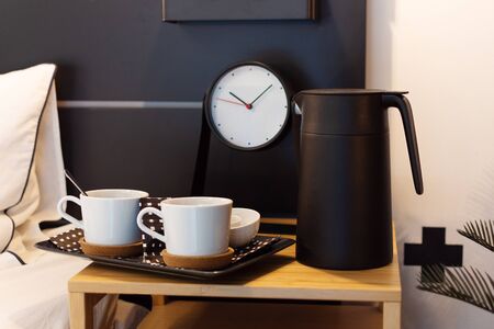 Morning coffee in modern interior decor near the bed. Coffee or tea in bed concept.