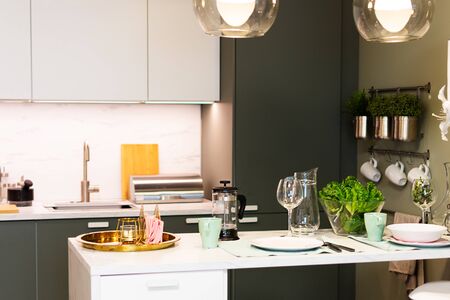 Modern table with utensils and vegetables over kitchen background. Modern kitchen interior and healthy eating concept.の写真素材