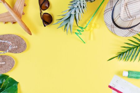 Colorful summer composition with straw hat, sunglasses, palm branche, pineapple, flip flops and others on yellow background top view. Summer fashion, travel concept.の写真素材