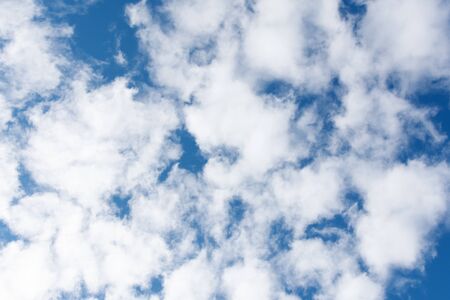 Blue sky background with white clouds in a sunny day. Texture of sky. Cloudscape.の写真素材