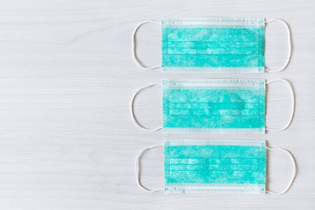 Medical mask for protection against cold and flu or other virus. Surgical protective mask top view. Medical respiratory bandage face on wooden background.の写真素材