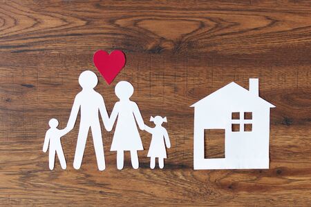 Lovely paper family with house on dark wooden background top view. Happy family, insurance concept.の写真素材