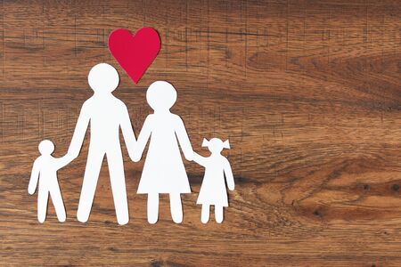 Happy paper family with heart on dark wooden background top view. Copy space.の写真素材