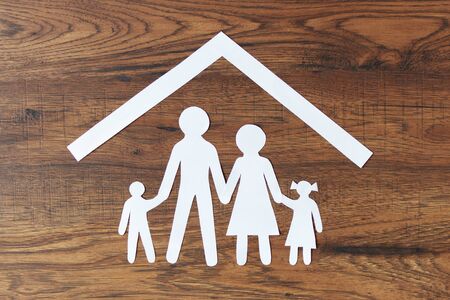 Lovely paper family with house on dark wooden background top view. Happy family, insurance concept.の写真素材