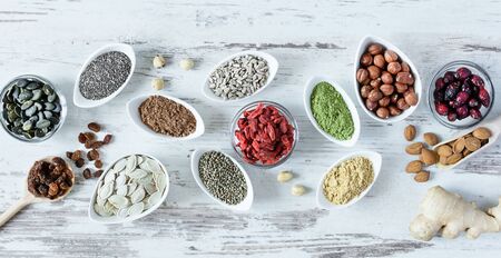 Small white bowls with various superfoods on white wooden background top view. Healthy eating concept.の写真素材