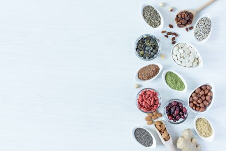 Small white bowls with various superfoods on white wooden background top view. Healthy eating concept. Copy space.の写真素材