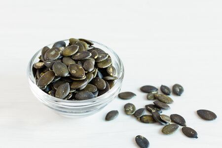 Peeled pumpkin seeds on white wooden background. Healthy eating concept. Super foods.の写真素材