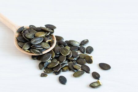 Peeled pumpkin seeds on white wooden background. Healthy eating concept. Super foods.の写真素材