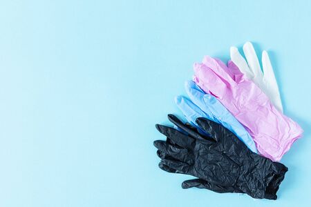 Pile of multi colored latex surgical gloves for protection on blue background top view.の写真素材