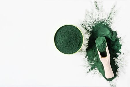 Organic green spirulina powder top view on white background. Super foods, food supplement source of vitamin protein and beta carotene.の写真素材