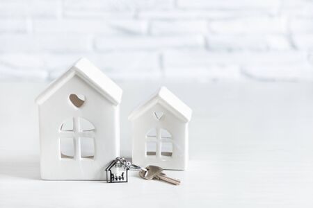 Toy house and key with keychain with family in a house shape. Real estate market concept. Rental housing.の写真素材