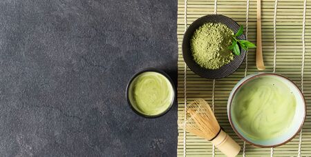 Green matcha tea drink and tea accessories on black background top view. Japanese tea ceremony concept. Chashaku spoon and chasen bamboo whisk for brewing matcha tea.の写真素材