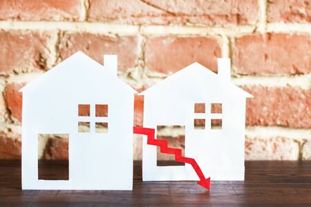 White houses with red arrow showing down. Real estate market rate down concept.の写真素材