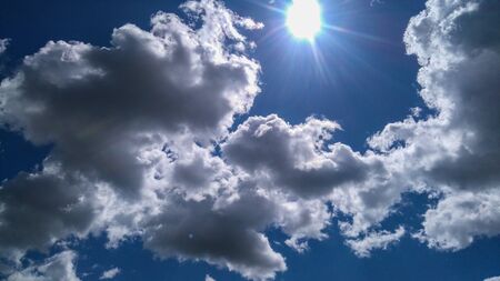 Sun rays on the cloudy blue sky. Sky texture.の写真素材