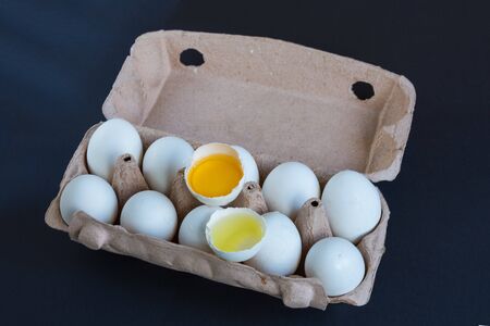 White eggs and one broken egg in the carton box with mockup to text. Natural protein. Healthy eating.の写真素材