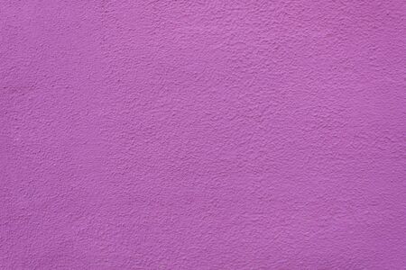 Background of painted rough stucco purple wall. Grunge violet cement texture.の写真素材