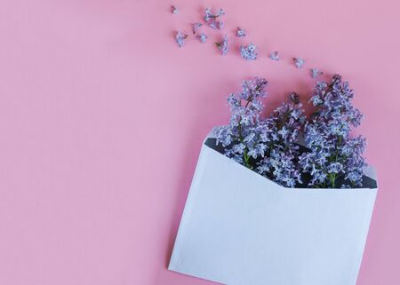 Envelope with lilac flowers on the pastel colorful background. Blank to text. Send congratulation.の写真素材