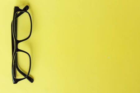 Spectacles on yellow background. Top view. Mockup for design. Healthy vision, trendy accessory.の写真素材
