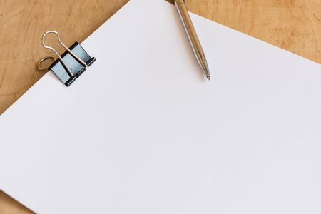Blank sheet of paper on wooden dest. Office workplace. Mockup for design.の写真素材