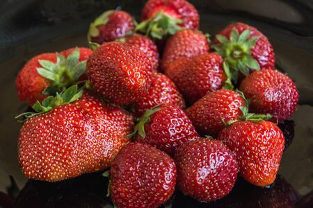 Sweet ripe strawberry on black plate closeup. Healthy lifestyle. Organic vitamins food.の写真素材