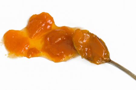 Spoon with sweet apricot fruit jam isolated on white background. Healthy vitamins dessert.の写真素材