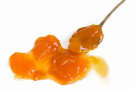 Spoon with sweet apricot fruit jam isolated on white background. Healthy vitamins dessert.の写真素材