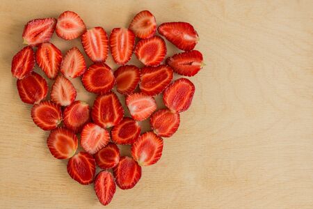 Strawberry heart shape on wooden table background. Sweet love concept. Copy space.の写真素材