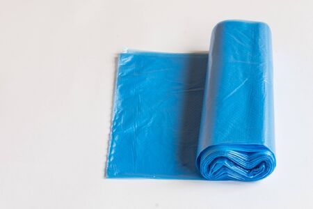 Roll of plastic garbage bag on white background. Waste blue bag for housework.の写真素材