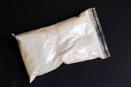 Drugs in a plastic bag on black background. Narcotic drugs addicted.