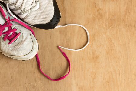 Man and woman fashion trendy trainers with lace heart on wooden background. Copy space.の写真素材