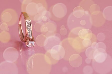 Engagement ring on sparkling light glitter background. Copy space. Mockup for design.の写真素材