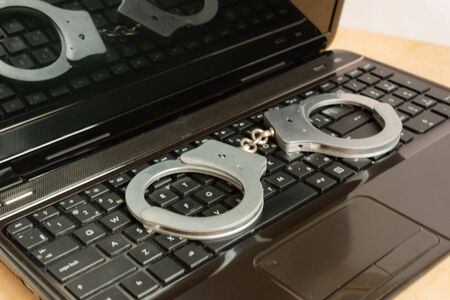 Computer keyboard and handcuffs top view. Criminal concept.の写真素材