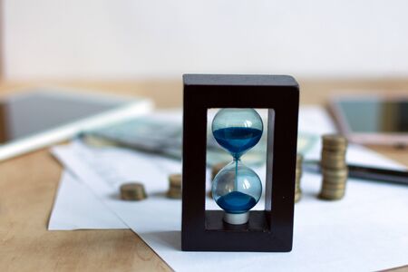 Hourglass and currency. Time is money concept.の写真素材