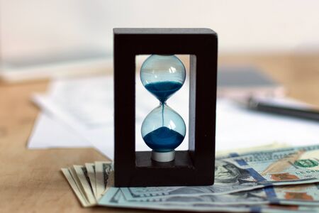 Hourglass and currency. Time is money concept.