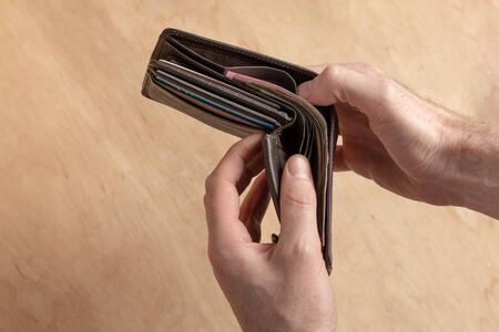 Man hold in his arm open purse with money. Finance success concept.