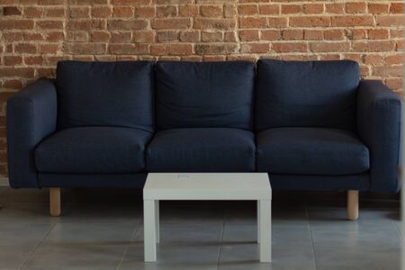 Modern living room interior. Soft sofa with white coffee table near brick wall background.の写真素材