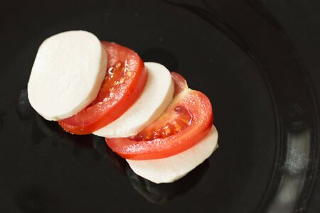 Mozzarella cheese with tomato. Mozzarella cheese cut by slices with tomatos. Ingredients for Caprese saladの写真素材