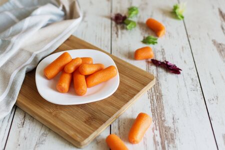 Small baby carrots on cutting board. Healthy eating concept. Dieting.の写真素材