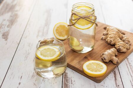 Ginger with lemon detox water in the morning on wooden background.の写真素材