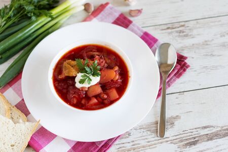 Traditional Ukrainian and Russian cuisine, soup cooked with beets and tomatoes. A white plate with...