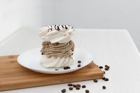 French vanilla meringue cookies with coffee cream on white background.