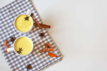 Golden turmeric milk with cinnamon and other aromatic spices top view. Healthy and aromatic detox...