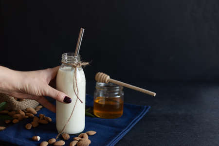 Fresh organic Almond milk in glass with almond nuts. Healthy eating concept.